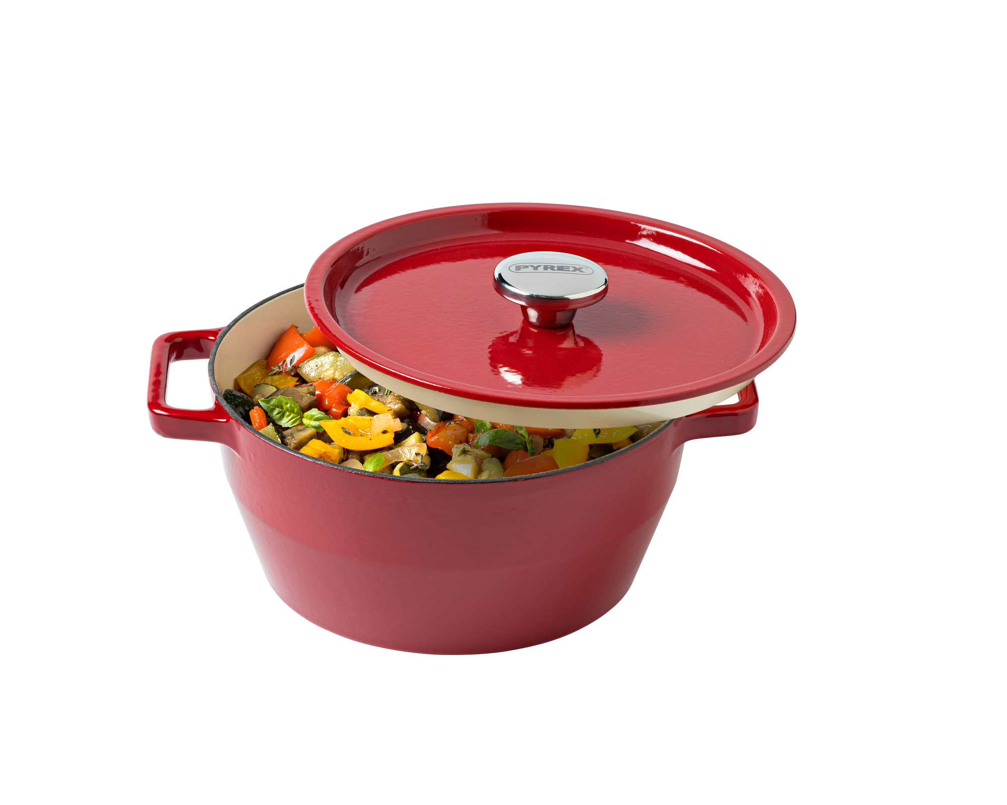 Red enameled cast iron Dutch oven with a lid filled with vegetables on a white background